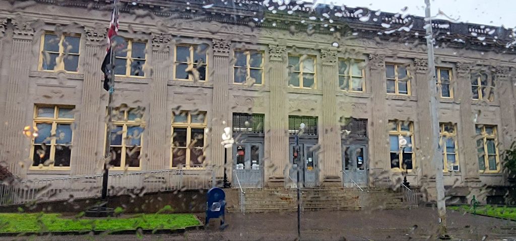 A photo of the downtown Astoria Oregon post office taken through a rain spattered car window
