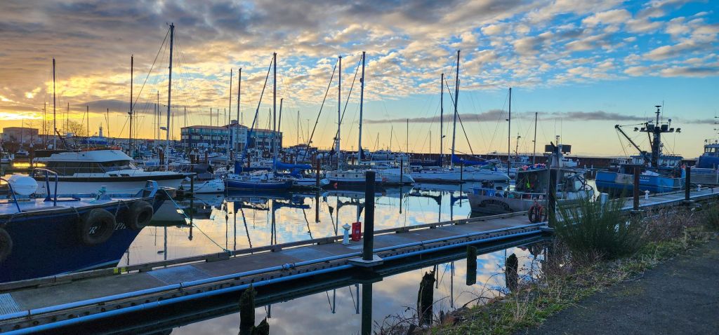 A color photo of the marina basin in Astoria Oregon at golden hour