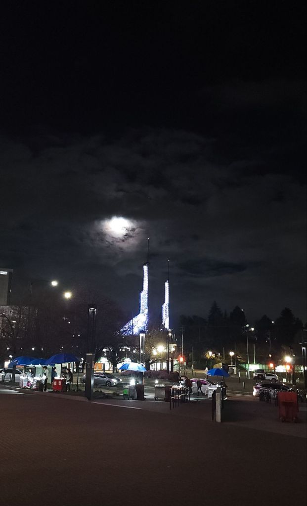 Outside the Moda Center in Portland with a full moon in the sky (except behind clouds)